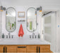 Modern bathroom with double mirrors, sleek faucet fixtures, and a stylish wooden vanity.