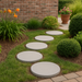 Round white concrete pavers used to form a durable pathway through a landscaped yard