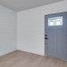 Interior view showcasing MDF Shiplap 5/8 in. x 6 in. x 16 ft. Primed 2010LDF on walls with a blue door.