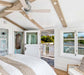 Bright interior of a bedroom featuring a ceiling fan, natural light, and a welcoming view through open doors and windows.
